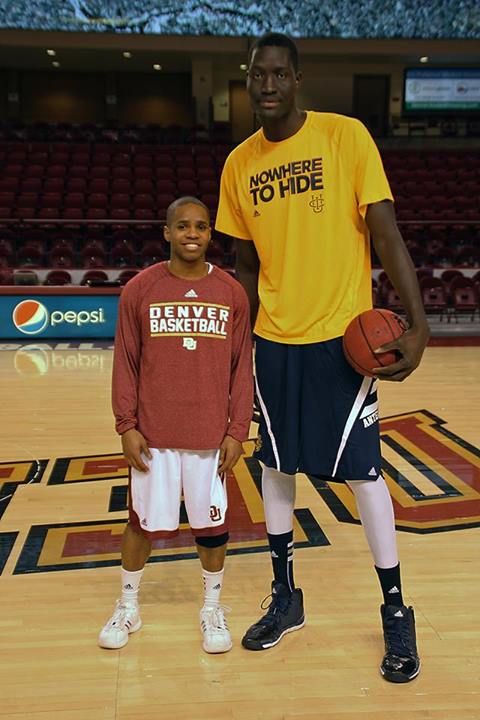 Giants of the Court: Wrestlers Standing Next to Basketball Players.